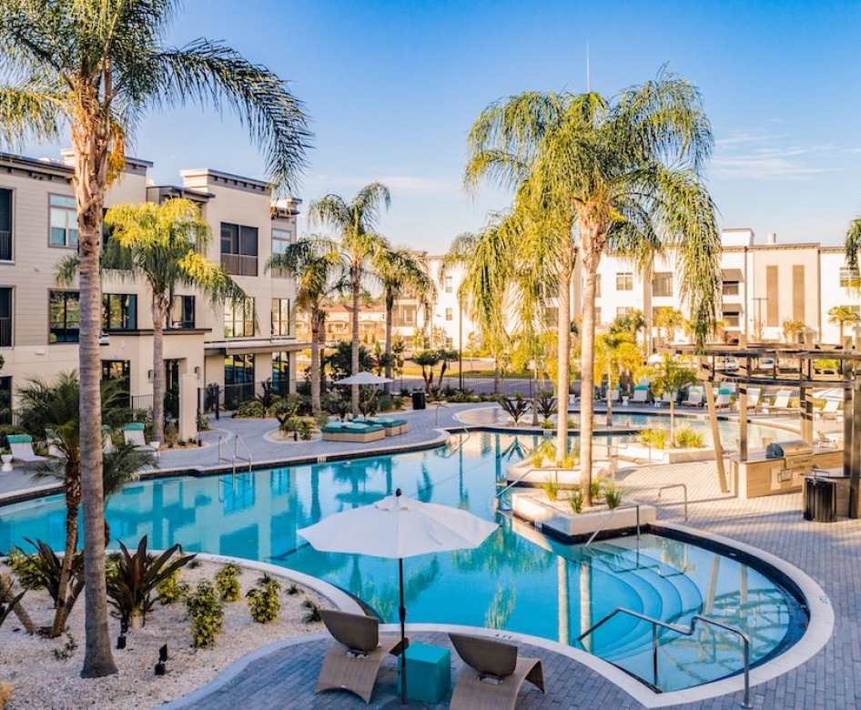 lounge chairs in swimming pool rest on tanning deck with fountains